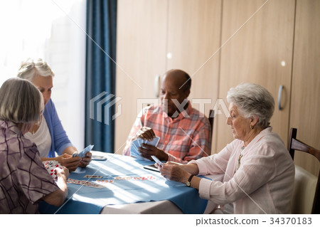 Senior people playing cards at table 34370183