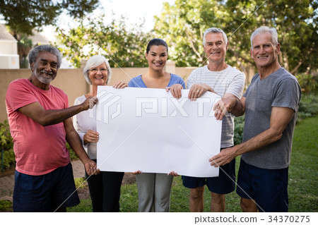 Portrait of senior people and trainer holding blank placard 34370275