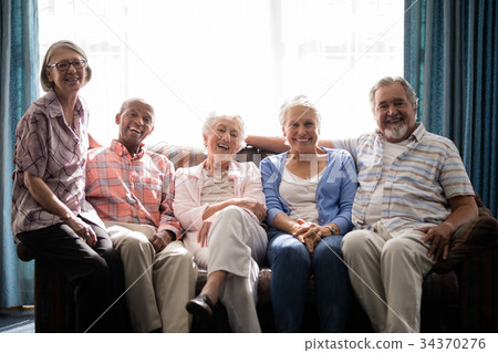Portrait of smiling senior people sitting on couch Portrait of smiling senior people sitting on couch 34370276