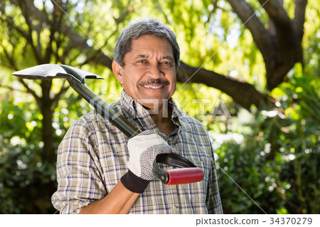 Senior man standing in garden on a sunny day 34370279