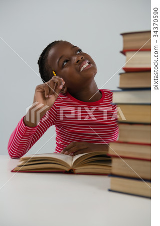 Schoolgirl doing his homework against white background Schoolgirl doing his homework against white background 34370590