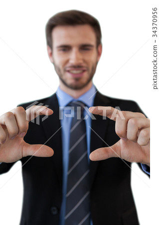 Smiling businessman showing invisible product 34370956