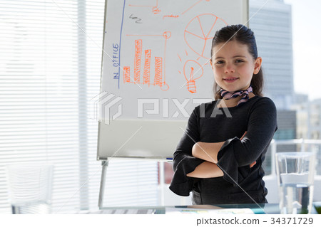Portrait of smiling businesswoman with arms crossed standing by whiteboard 34371729