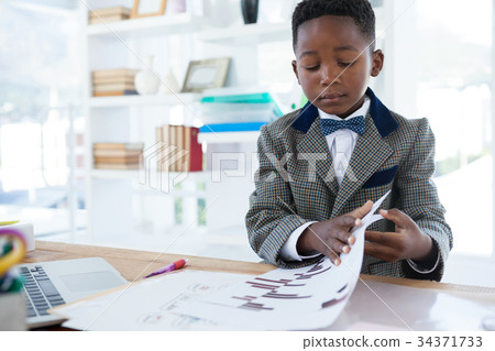 Confident businessman reading document at desk 34371733