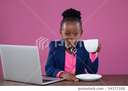 Portrait of businesswoman having coffee while making face 34372388