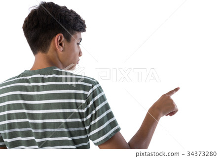 Teenage boy pressing an invisible virtual screen against white background Teenage boy pressing an invisible virtual screen against white background 34373280