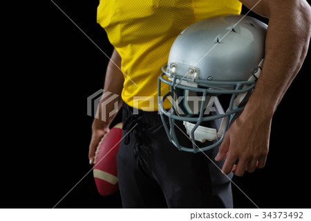 American football player holding a ball and head gear 34373492