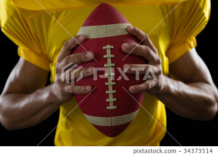 American football player holding a ball American football player holding a ball 34373514