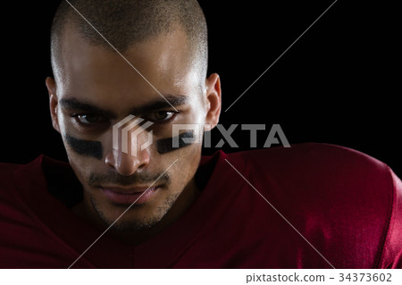 Determined American football player against a black background 34373602