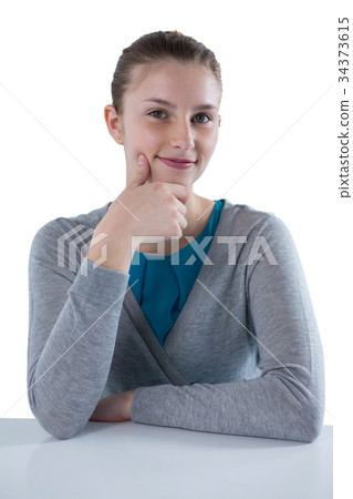 Smiling teenage girl sitting against white background Smiling teenage girl sitting against white background 34373615