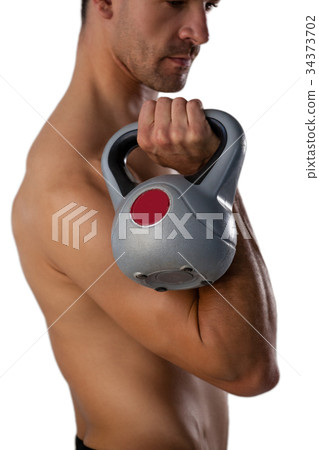 Side view of shirtless sports man exercising with kettle bell 34373702