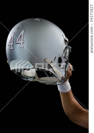 American football player holding a head gear raised American football player holding a head gear raised 34373827