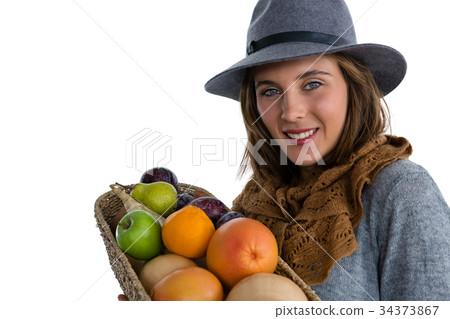 Portrait of smiling woman carrying fruits and vegetables in basket 34373867