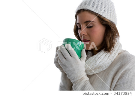 Close up of woman in warm clothing having coffee Close up of woman in warm clothing having coffee 34373884