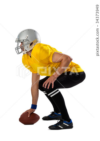 Side view of determined American football player bending with ball 34373949