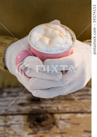 Mid section of woman having hot chocolate 34374153