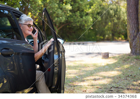 Senior woman talking on mobile phone in car 34374368