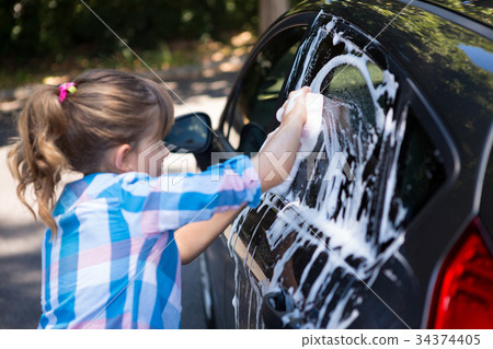 Teenage girl washing a car 34374405