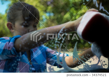 Teenage girl washing a car 34374521