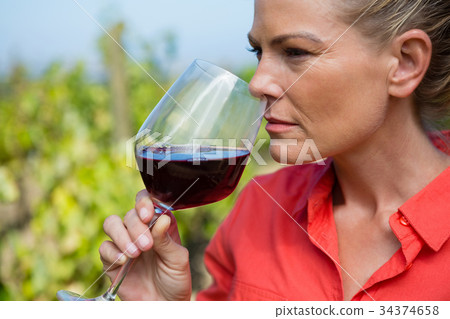 Female vintner smelling glass of wine Female vintner smelling glass of wine 34374658