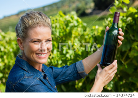 Portrait of female vintner examining wine Portrait of female vintner examining wine 34374724