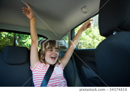 Teenage girl sitting in the back seat of car Teenage girl sitting in the back seat of car 34374819