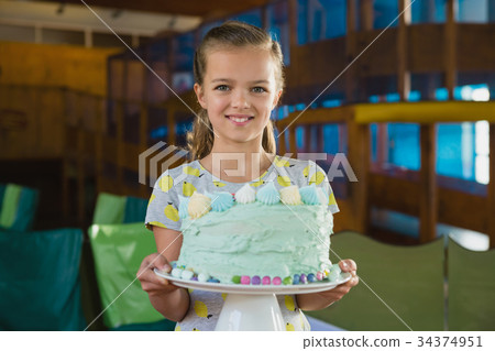Portrait of smiling girl holding cake 34374951