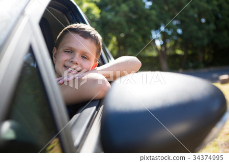 Teenage boy sitting in the back seat of car 34374995
