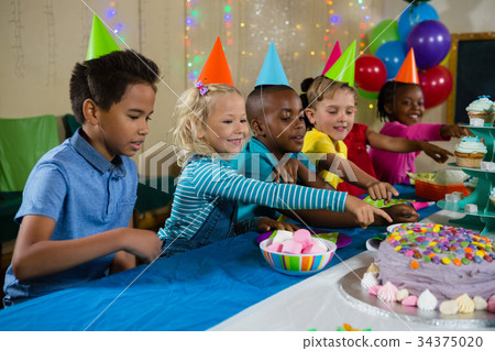 Kids pointing on cake 34375020