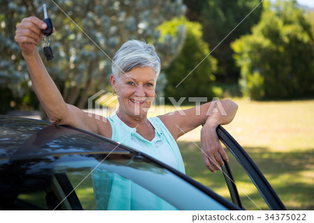 Senior woman holding a car key in park 34375022