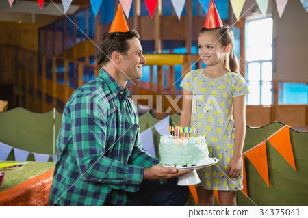 Father giving surprised birthday cake to her daughter Father giving surprised birthday cake to her daughter 34375041