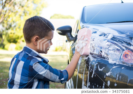Teenage boy washing a car Teenage boy washing a car 34375081
