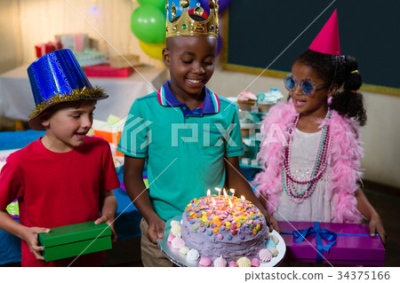 Smiling boy holding birthday cake Smiling boy holding birthday cake 34375166
