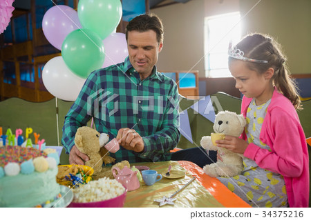 Father and girl playing toy kitchen set 34375216