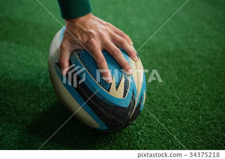 Cropped hand of person with rugby ball Cropped hand of person with rugby ball 34375218