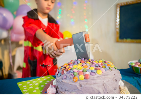 Cute boy pretending to be a fireman during birthday party Cute boy pretending to be a fireman during birthday party 34375222