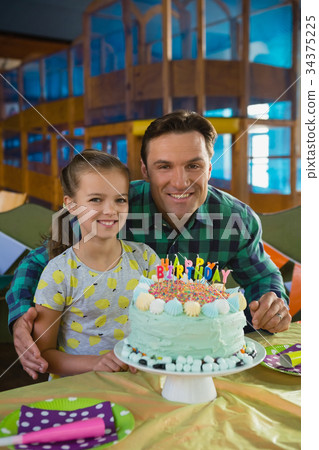 Father and daughter with birthday cake at home Father and daughter with birthday cake at home 34375225