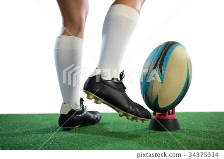 Low section of sportswoman kicking rugby ball 34375314