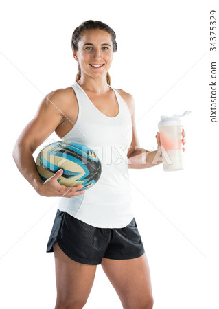 Portrait of happy female rugby player with ball and drinking bottle Portrait of happy female rugby player with ball and drinking bottle 34375329