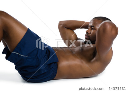 Shirtless male athlete practicing sit ups Shirtless male athlete practicing sit ups 34375381