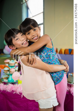 Kids embracing each other during birthday party at home 34375408