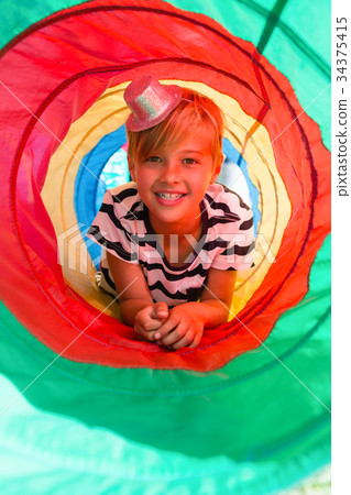 Portrait of boy lying in tent tunnel 34375415