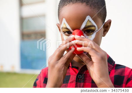 Close up portrait of boy wearing clown nose 34375430