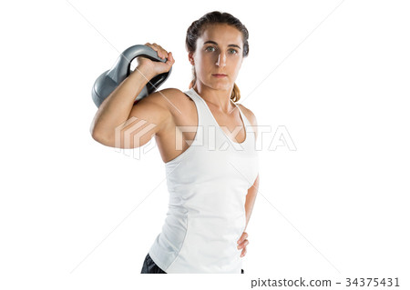 Portrait of female athlete holding kettlebell Portrait of female athlete holding kettlebell 34375431