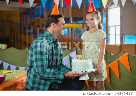 Father giving surprised birthday cake to her daughter 34375457