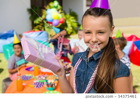 Portrait of girl showing gift box 34375461