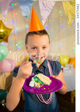 Girl eating cake during birthday party at home 34375462