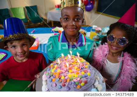 High angle portrait of boy holding birthday cake High angle portrait of boy holding birthday cake 34375489