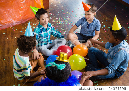 High angle view of children sitting with holding hands High angle view of children sitting with holding hands 34375596
