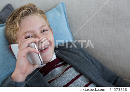 Little boy playing with phone on couch 34375818